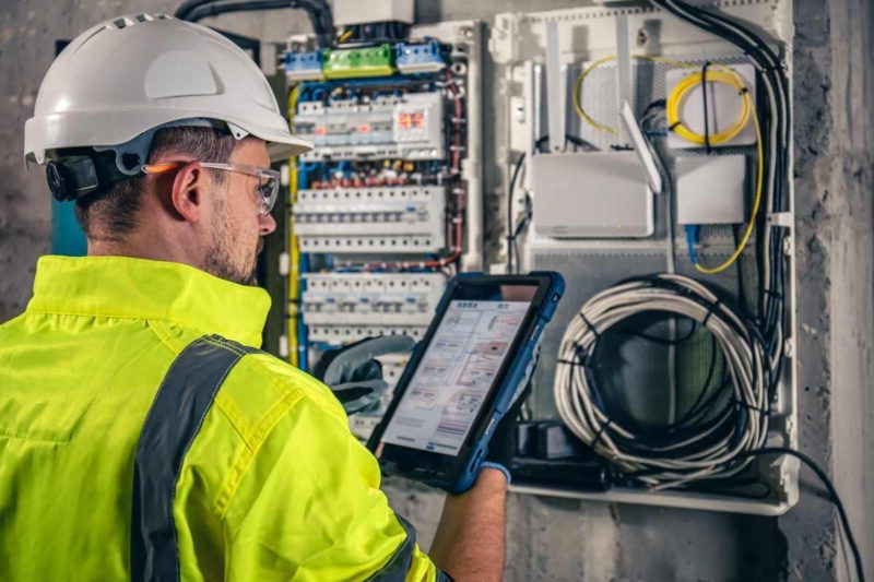 Technician performing test and tag for electrical compliance in a Sydney workplace.