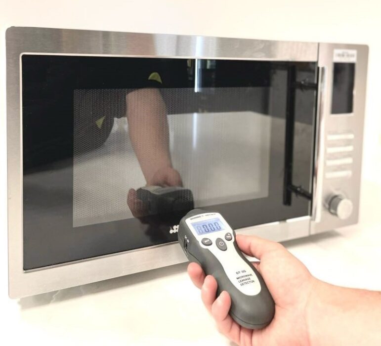 Microwave oven being tested for radiation leakage using a microwave radiation leakage tester as part of the test and tag safety compliance process.